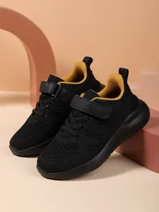 Gedetailleerd overzicht van ademende zwarte mesh-sneakers voor kinderen met gele voering