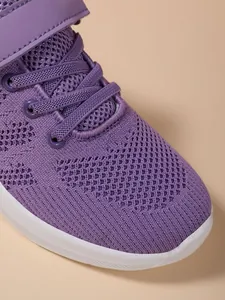 Gedetailleerde opname van de ademende paarse mesh-stof op sportschoenen voor meisjes
