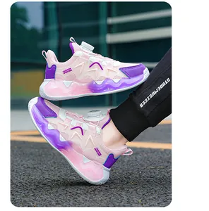 Dettaglio delle scarpe da basket per bambini rosa e viola con sistema a fibbia rotante.