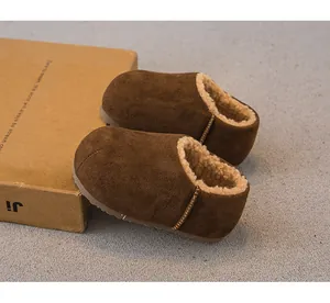 Nahaufnahme brauner Kinderhausschuhe mit warmem Fleece-Futter und Wildleder-Finish