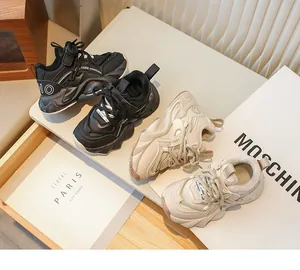 Détail de baskets chunky fourrées noir et beige pour filles sur une étagère.