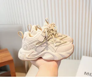 Gros plan de baskets chunky beiges fourrées pour filles tenues à la main