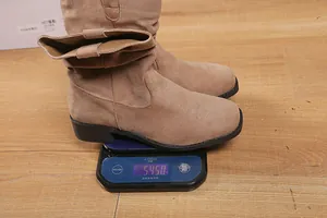 Close-up showing the weight of a brown suede western slouch boot on a digital scale