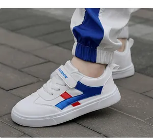 Detalle de zapatillas blancas para niños con rayas rojas y azules y tiras de velcro