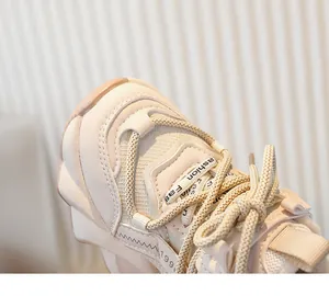 Gros plan sur la doublure en polaire chaude et les lacets texturés des baskets crème pour filles