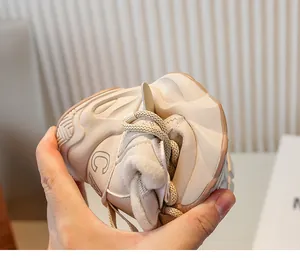 Gros plan montrant l'extrême souplesse de la semelle des baskets fourrées pour enfants beige.