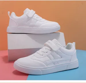 Primer plano de zapatillas blancas para niños con cierre de velcro y diseño bajo.