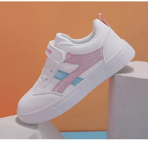 Vista detallada de zapatilla blanca para niños con rayas brillantes rosa y azul