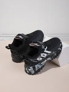 Detailed view of children's breathable mesh running sneakers with stylish graffiti pattern soles