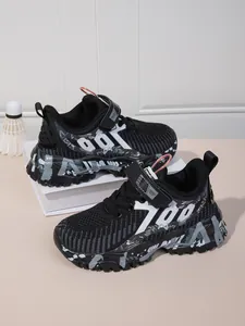 Close-up of black mesh kids sneakers with graffiti '700' patterns on chunky soles