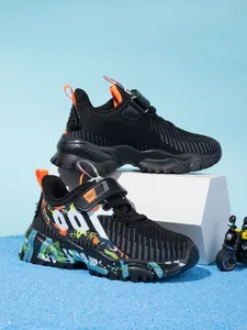 Close-up view of breathable mesh boys' running shoes in black and graffiti colors.