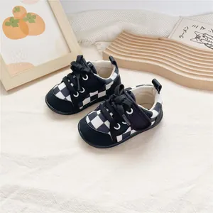 Macro view of soft-soled baby walking shoes with classic black and white checkerboard print