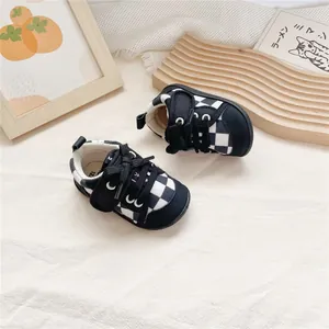 Stylish black and white checkerboard baby walking shoes with soft rubber soles