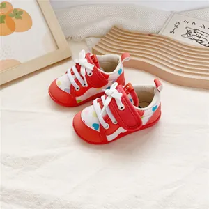 Detailed view of red baby walker shoes with soft soles and colorful heart patterns.