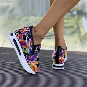 Primer plano detallado de zapatillas de cuña con bordado paisley de colores para mujer