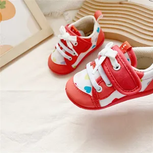 Detail of soft-sole baby walking shoes with colorful heart patterns and red accents