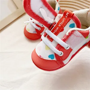 Detailed close-up view of red and white baby walker shoes featuring cute heart patterns