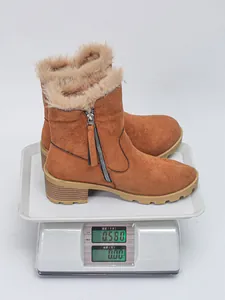 Detail view of brown suede winter snow boots weighing 0.580 kg on a digital scale device