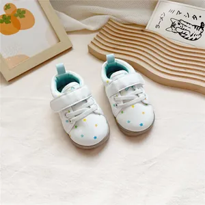 Detailed view of white toddler leather shoes with vibrant star prints and velcro straps