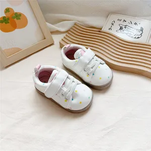 Detailed view of white toddler walking shoes with vibrant colorful heart patterns