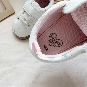 Close-up of baby shoe interior showing pink breathable insole with size marking and logo