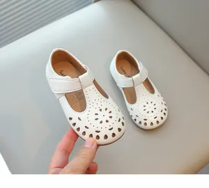 Close-up detail of white hollow-cut girl's princess shoes featuring a soft sole design.
