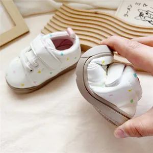 Close-up of flexible soft-sole baby walking shoes showing sole flexibility and heart pattern