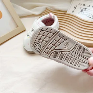 Close-up view showing the soft anti-slip rubber sole of white toddler walking shoes
