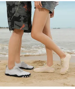Detail view of quick-dry water shoes worn on a sandy beach by a couple