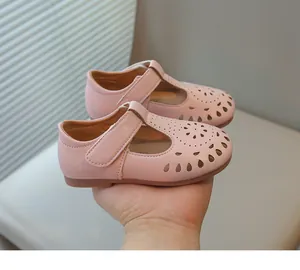 Macro view of pink girls' leather princess shoes with floral hollow-out pattern detail