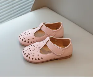 Close-up of the delicate hollow-out pattern on pink girl's Mary Jane princess shoes