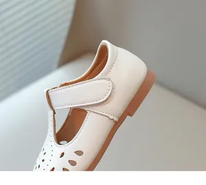 Close-up detail of elegant white girls princess shoe with hollow-out floral pattern