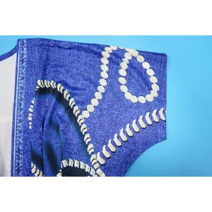 Detalle de cerca del estampado denim y patrón de perlas blancas en la manga del vestido