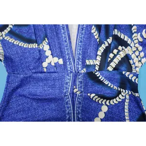 Primer plano del patrón estampado y el escote en V de un vestido azul de corte entallado.