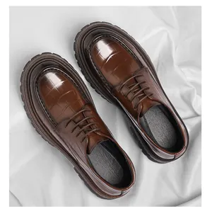 Détail de chaussures Derby à plateforme pour hommes en cuir marron motif crocodile.