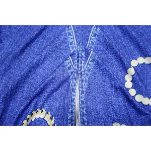 Detalle de cerca del cuello en V y la textura denim azul en vestido estampado de moda.
