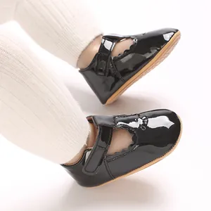 Close-up of black patent leather baby princess shoes with scalloped edges