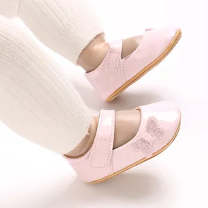 Close-up of pink baby girl princess shoes with glittery bow and patent leather finish