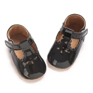 Detailed view of black patent leather baby shoes with scallop edges and velcro strap