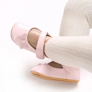Close-up detail of a pink patent leather baby girl princess shoe with glittery bow decoration
