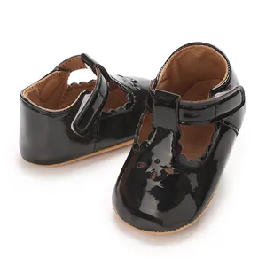 Detailed view of black patent leather baby Mary Jane shoes with scalloped edges