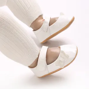 Detailed view of white patent leather baby girl princess shoes with sweet bow accent