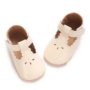 Top-down view of beige baby princess shoes with scalloped trim and flower cutouts