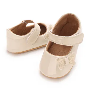 Detailed macro view of glossy beige infant princess shoes with a glitter butterfly.