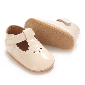 Detail of beige patent leather baby princess shoes with scalloped edges and non-slip sole