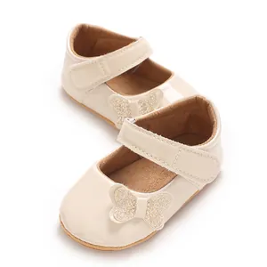 Cream colored baby girl princess shoes featuring a sparkly glitter butterfly decoration