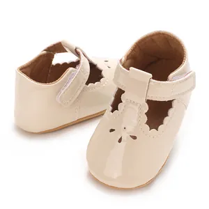 Close-up of cream patent leather baby princess shoes with elegant scallop edges and flower cutouts