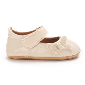 Close-up side view of cream patent leather baby princess shoe with glittery butterfly detail