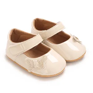 Detail view of beige patent leather baby princess shoes with glittery butterfly