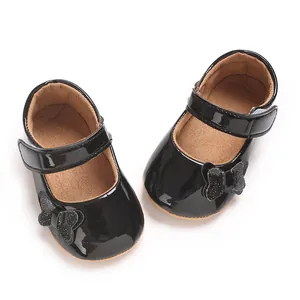 Detailed top view of black patent leather baby princess shoes with a glittery bow